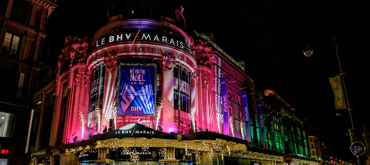 Façade du BHV Marais magnifiquement décorée pour Noël à Paris, avec lumières, projections et ambiance féerique.